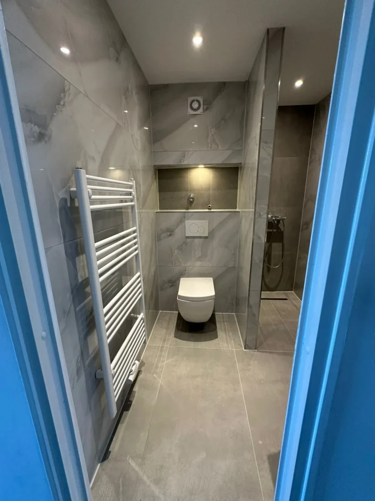 Komplett renoviertes Badezimmer mit modernen Fliesen, Hänge-WC und Walk-in-Dusche – Fachgerechte Badsanierung durch DXB Handwerksarbeiten in Braunschweig, Hannover, Hamburg und Soltau